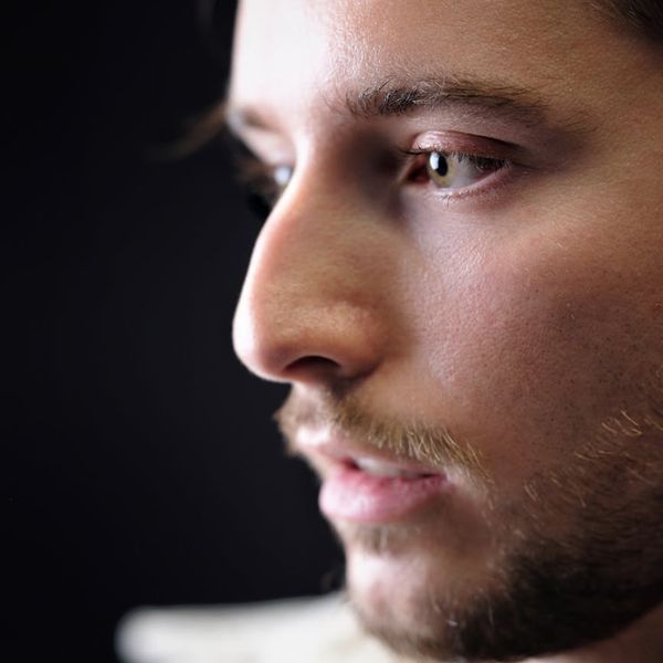 Close-up of a person's eye looking intently, with a soft light reflection, suggesting focus.
